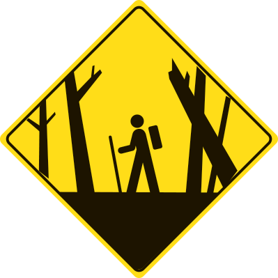 A yellow diamond warning sign with a hiker and hazardous trees.