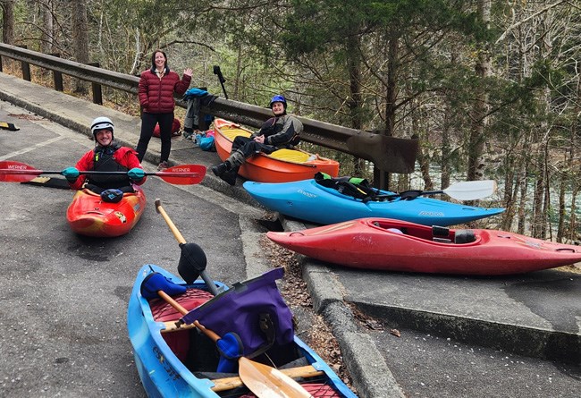 a group of paddlers getting ready in a parking lot