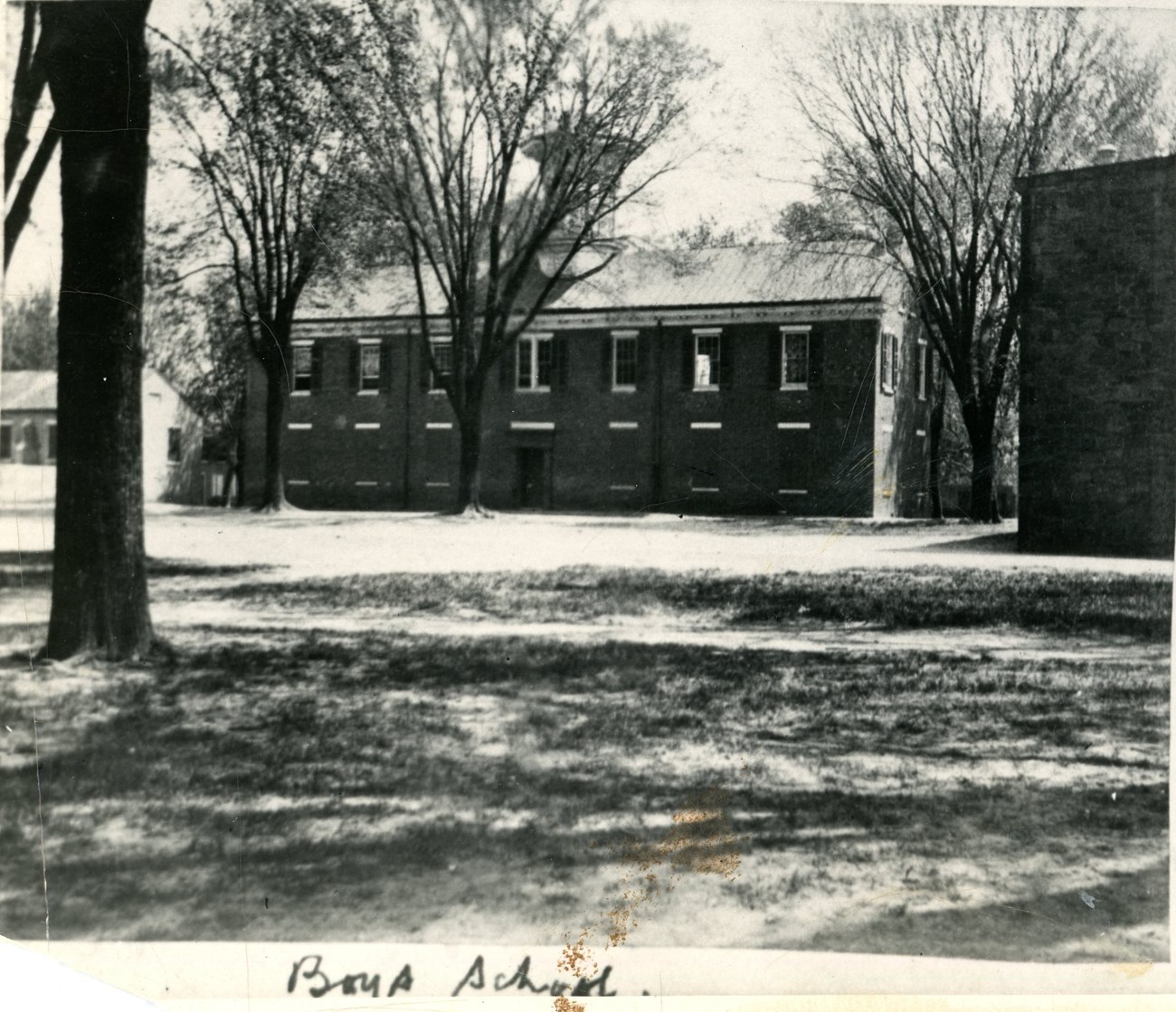 A two story brick building with a cuppola on the roof.