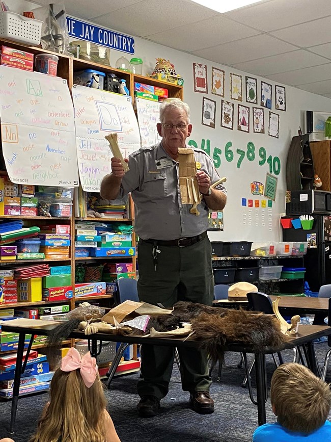 A park ranger presents to a group of school-age children