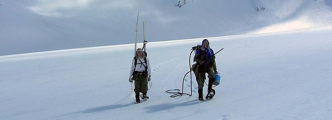 Two researchers snowshoeing