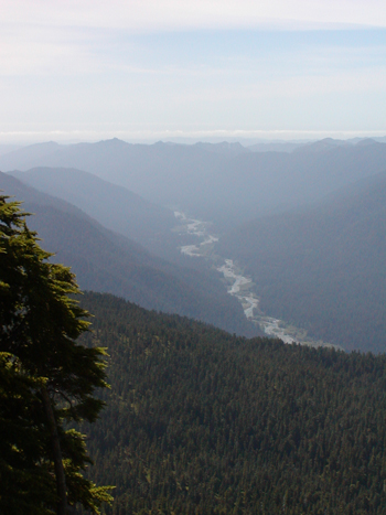 A view of a river valley from above on a high ridge. The river valley stretches far into the distance.