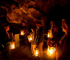 A tour group participating in a Candlelight Cave Tour.