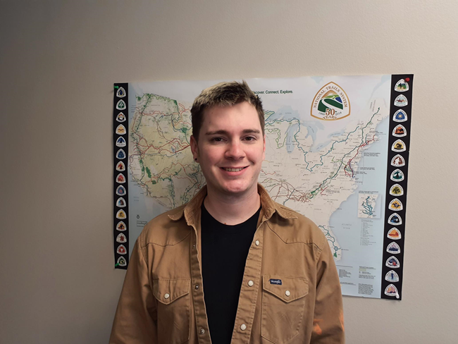 A person stands in front of a map.