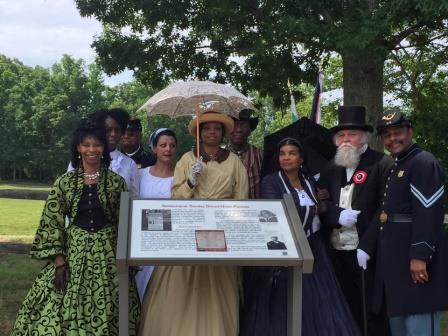 Men and women in period dress gather around a wayside marker during the dedication of an African American Walking Trail in Spotsylvania, Virginia.