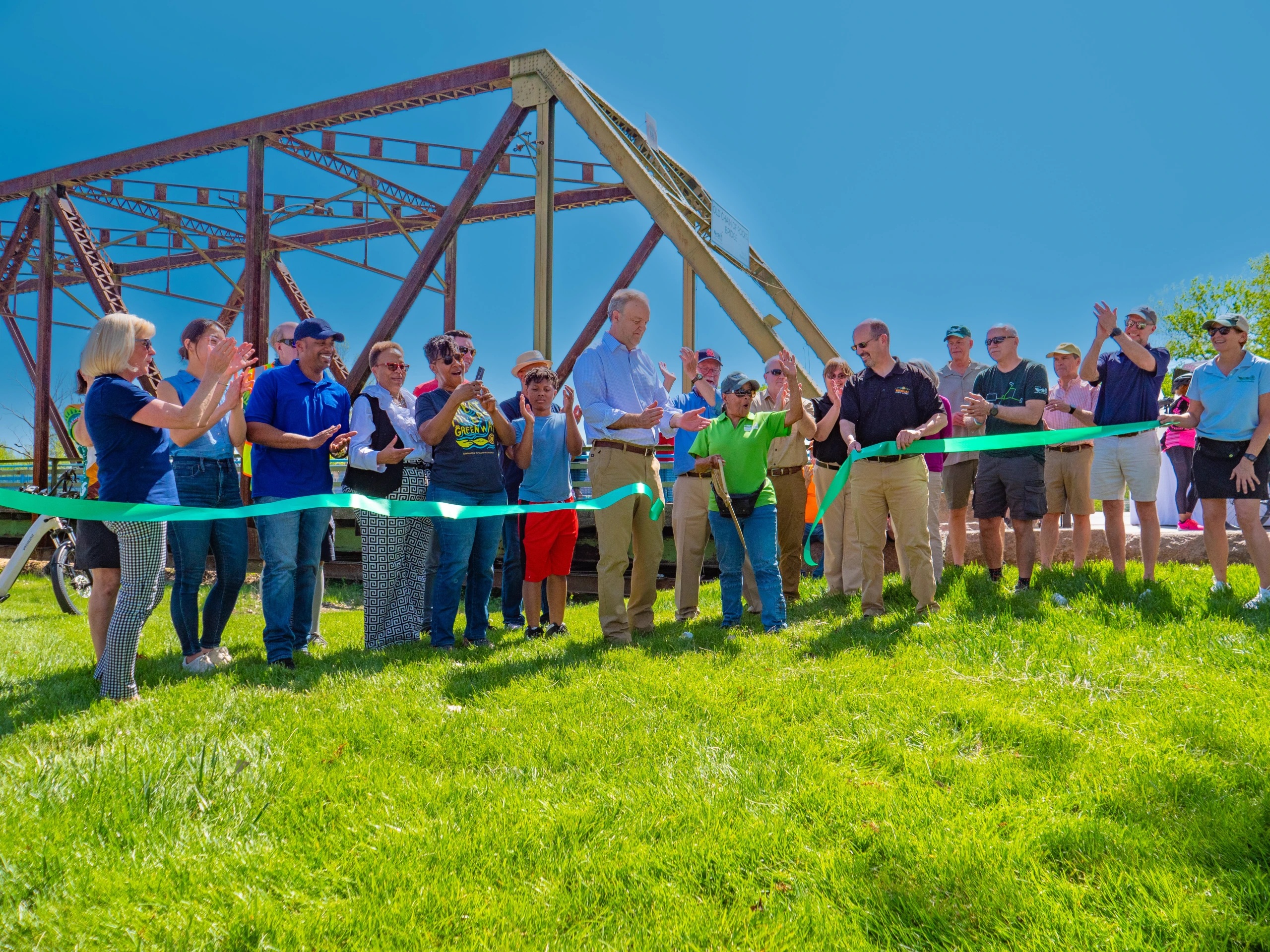 Group cutting a ceremonial ribbon on a lawn
