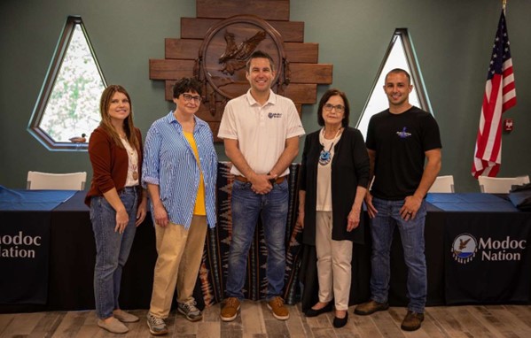 A group of five individuals pose for a photo.