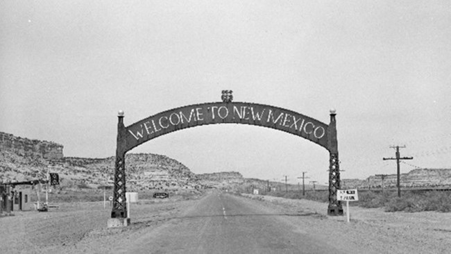 historic image of an arch stretching over a road, "state line."