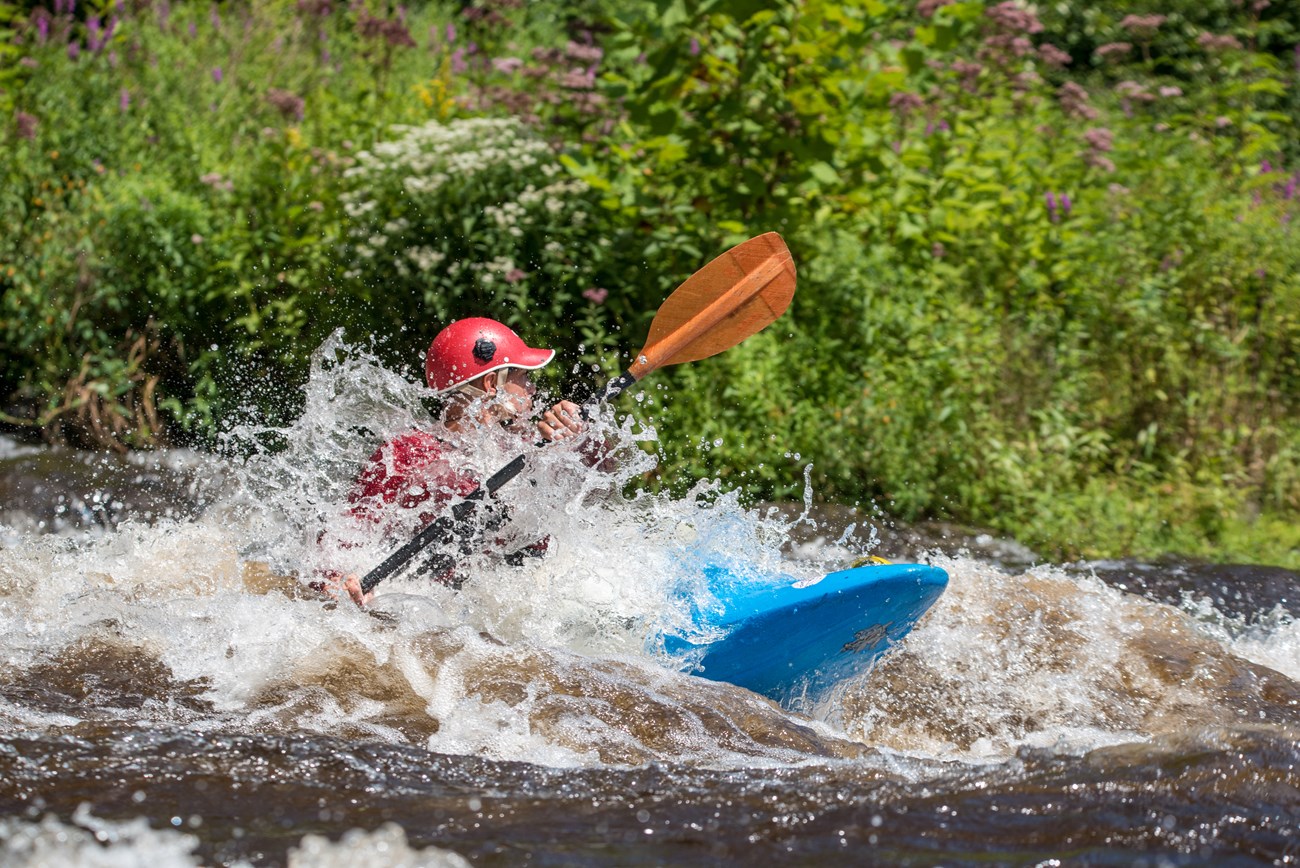 A kayaker paddles through rough waters
