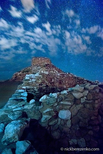 Stone walls with bluish tint and starry sky and clouds above