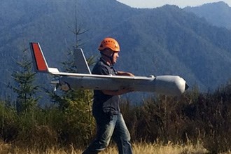 man carrying a drone outside