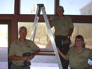 Volunteers pose after hanging new blinds in the visitor center