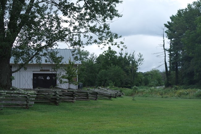 Building with wooden fence and grassy meadow