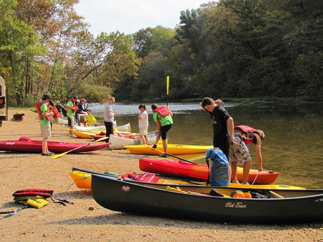 Ranger on river bank giving instruction to participants