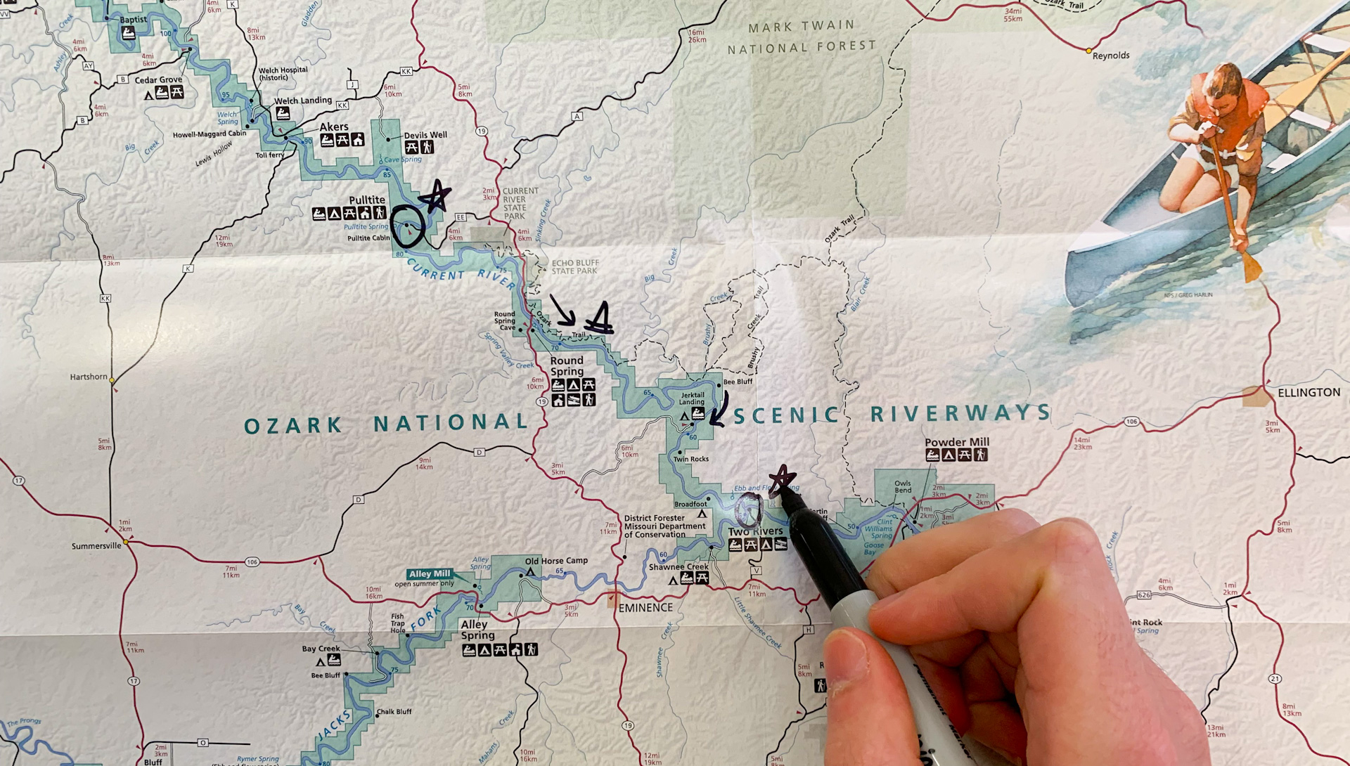 A person uses a sharpie to draw on a park map.