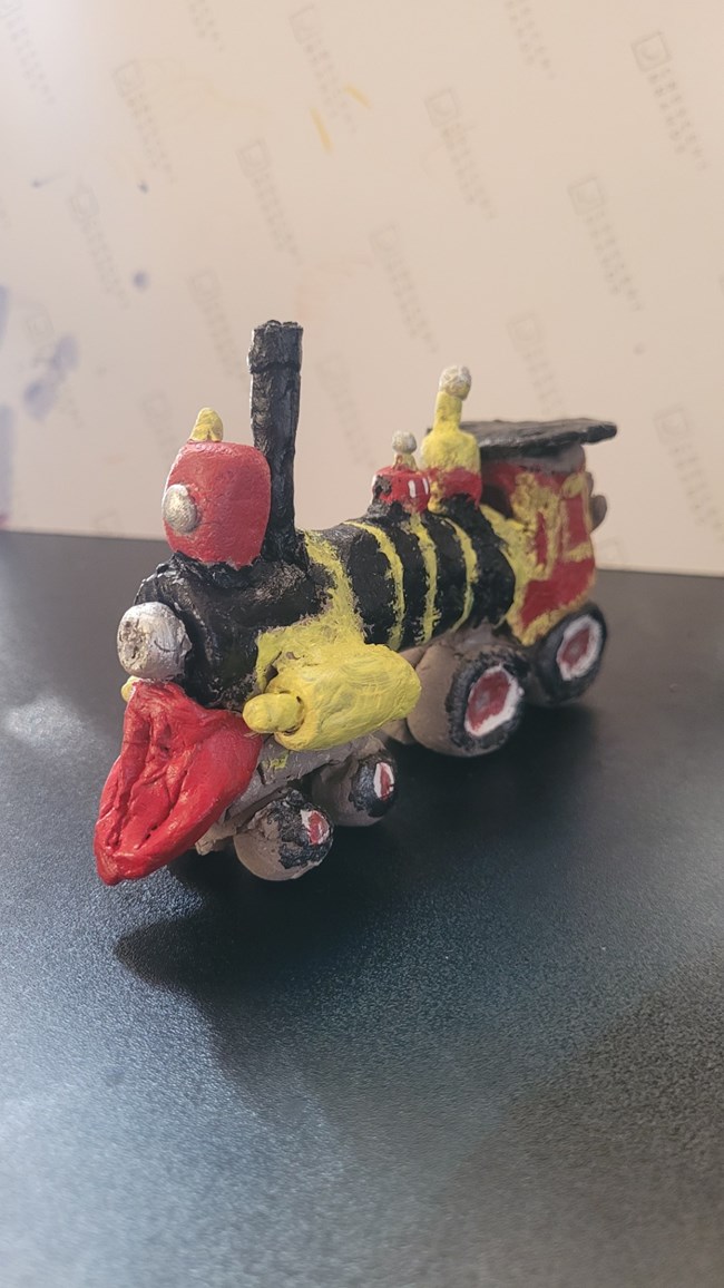 train with black , red an yellow painted pieces