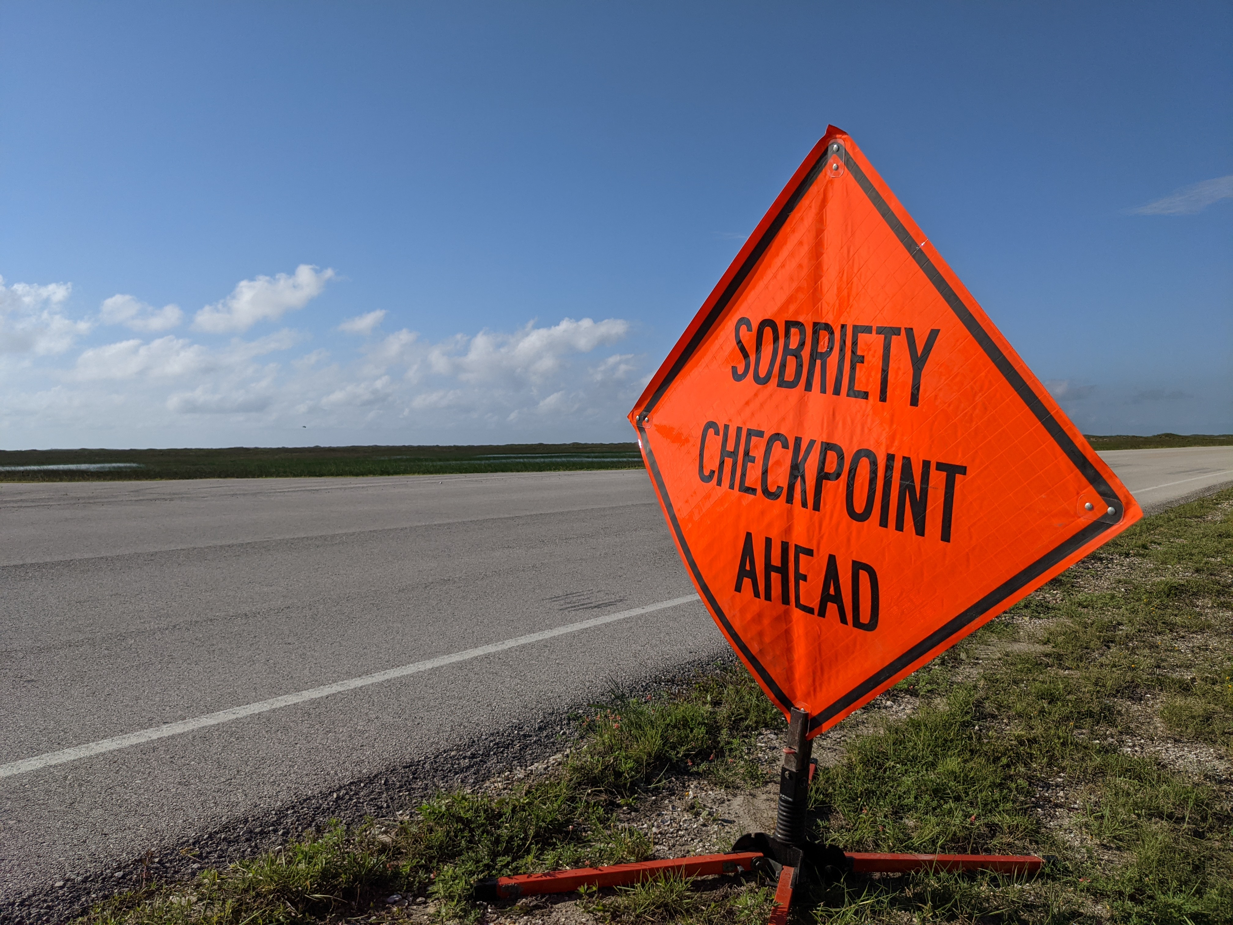 Orange sign that reads "Sobriety Checkpoint Ahead"