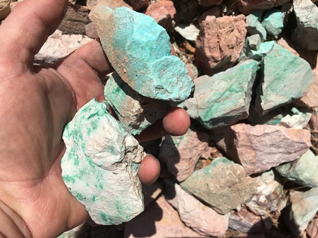 Green ore stones in a person's hand