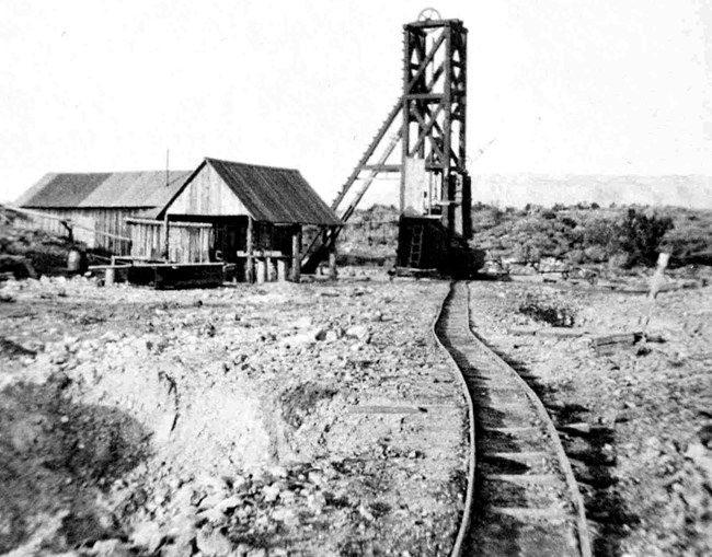 Ore Cart tracks to the headframe made of wood and steel over mine shaft