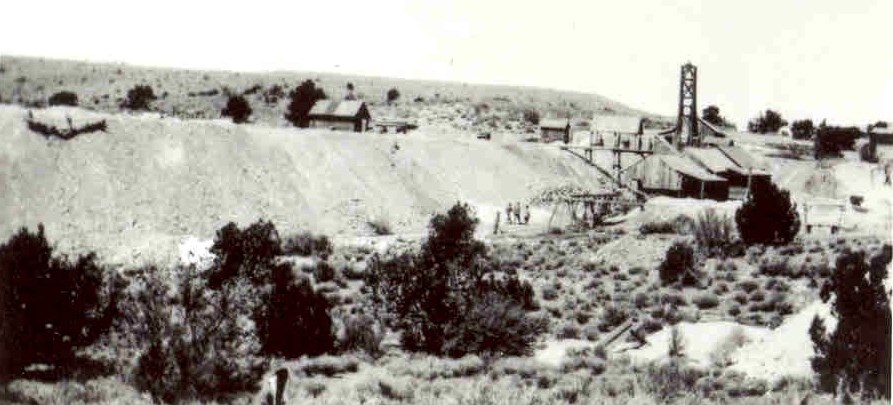 Image taken in 1917 showing several mine workers, a 100 foot long pile of rocks and several mine buildings