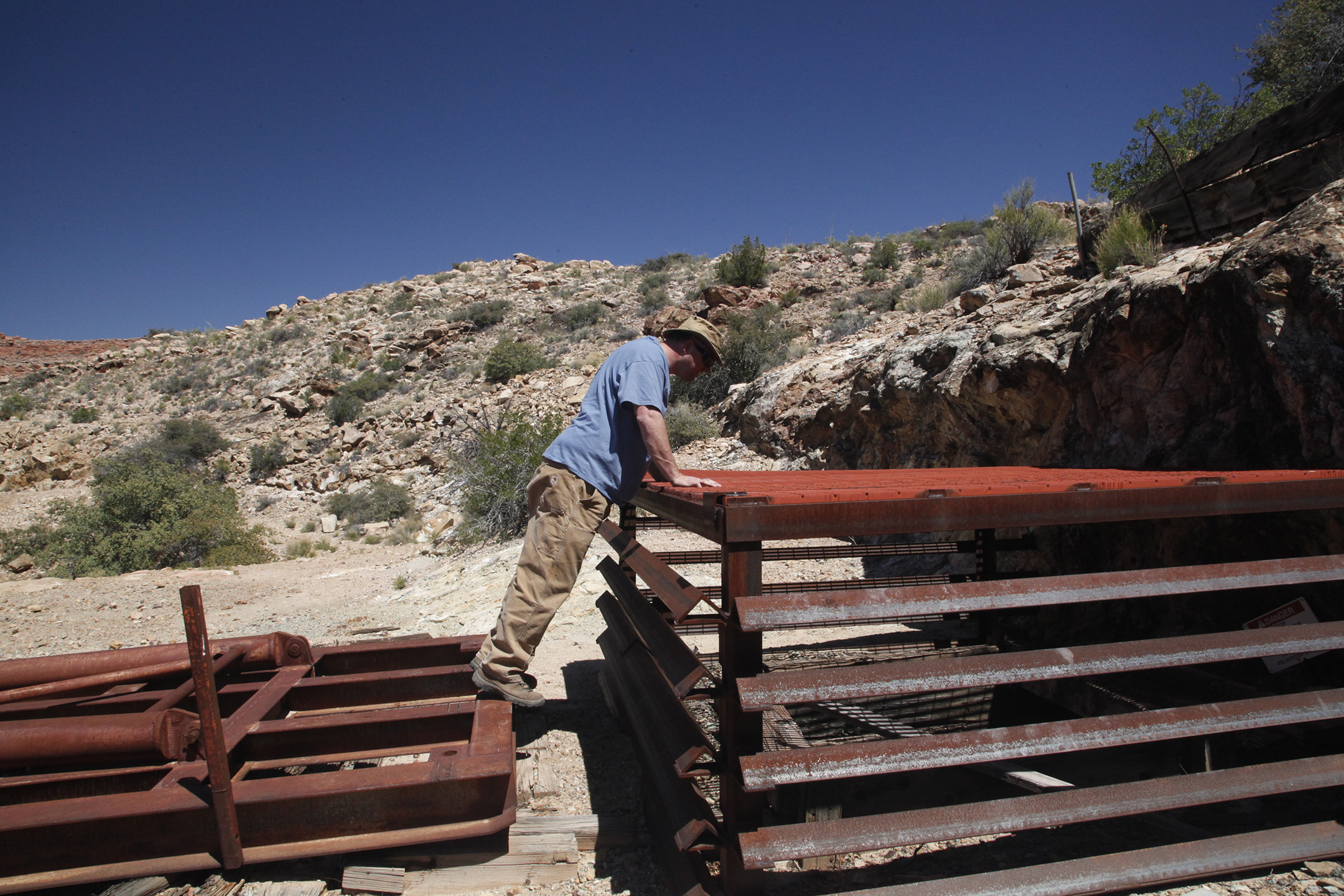 Visitor looking through steel grate down into the mine