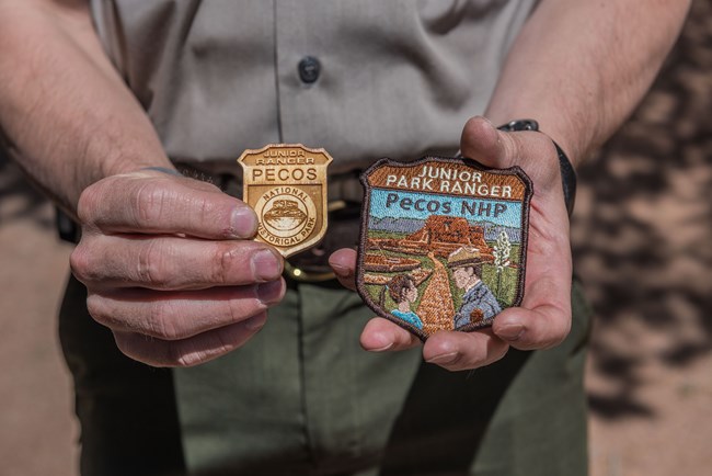 wooden badge and patch held in park rangers hands