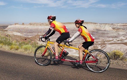 Two people riding a tandem bicycle through Blue Mesa