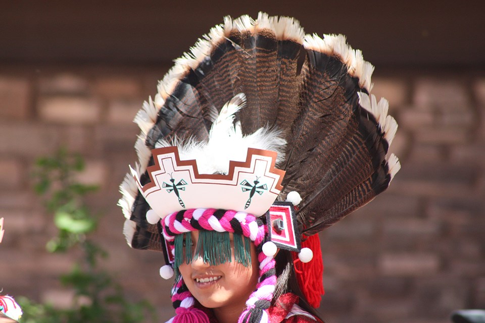 Zuni Dancer in colorful outfit with large feather headdress