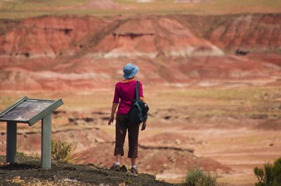 Woman enjoys the view of the red Painted Desert from the Rim Trail