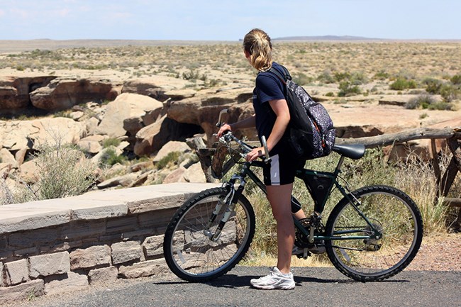 A bicyclist stops for a view at Newspaper Rock