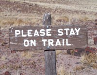 wooden sign asking visitors to Please Stay on Trail