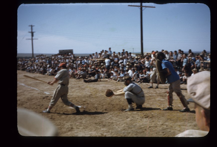 A crowd watches a live baseball game.