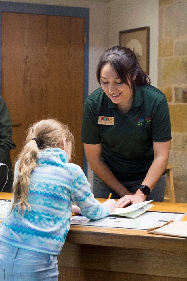 Female talking to a child about an activity book