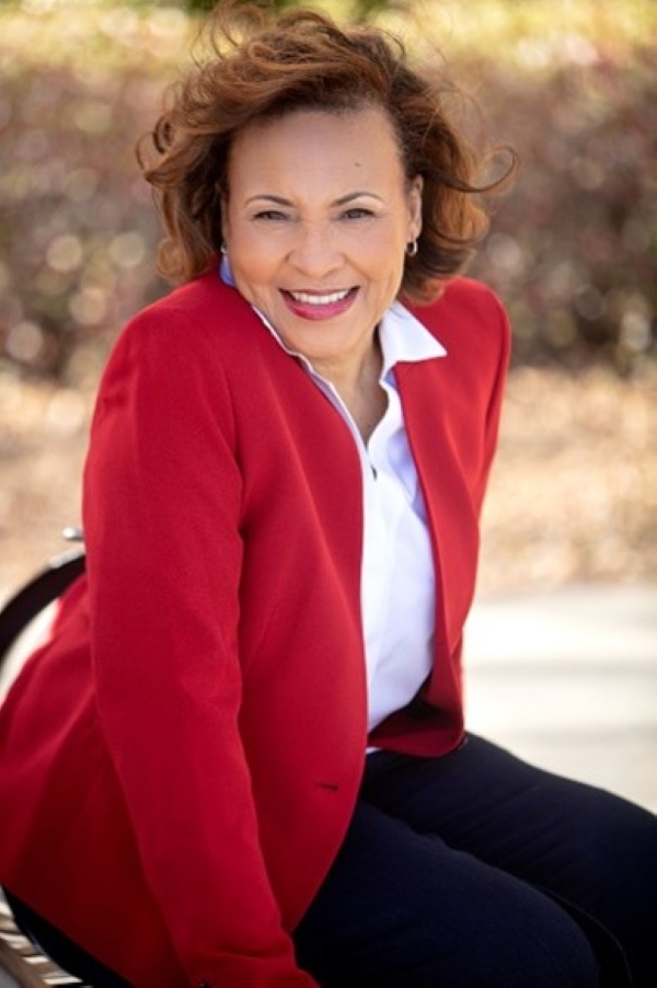 Photo of woman with red jacket and white shirt.