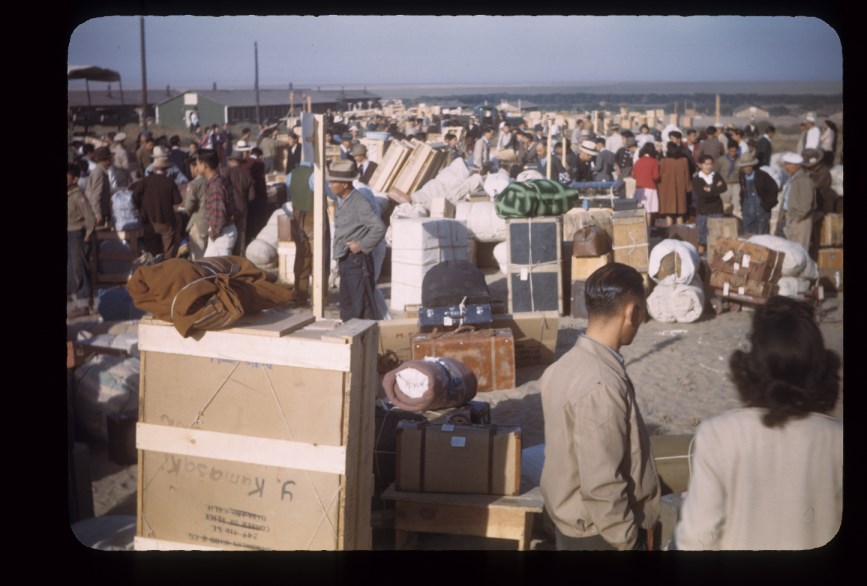 A crowd of people carrying suitcases and other items.