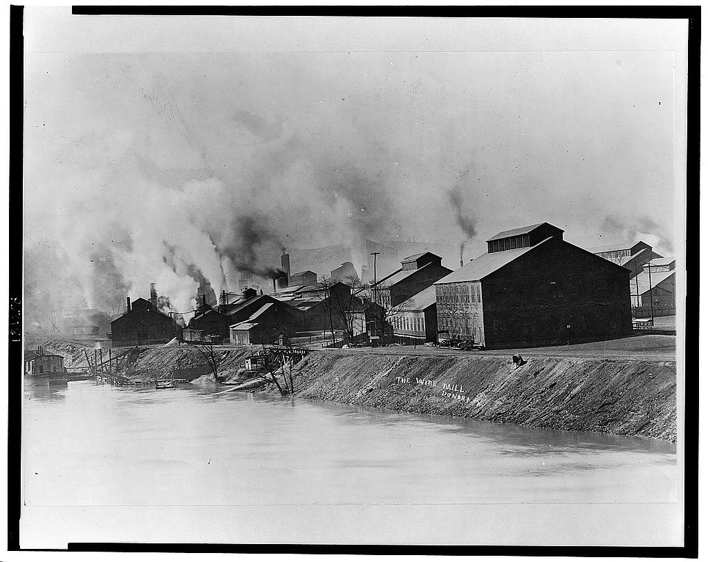 Black and white photo of buildings spewing smoke