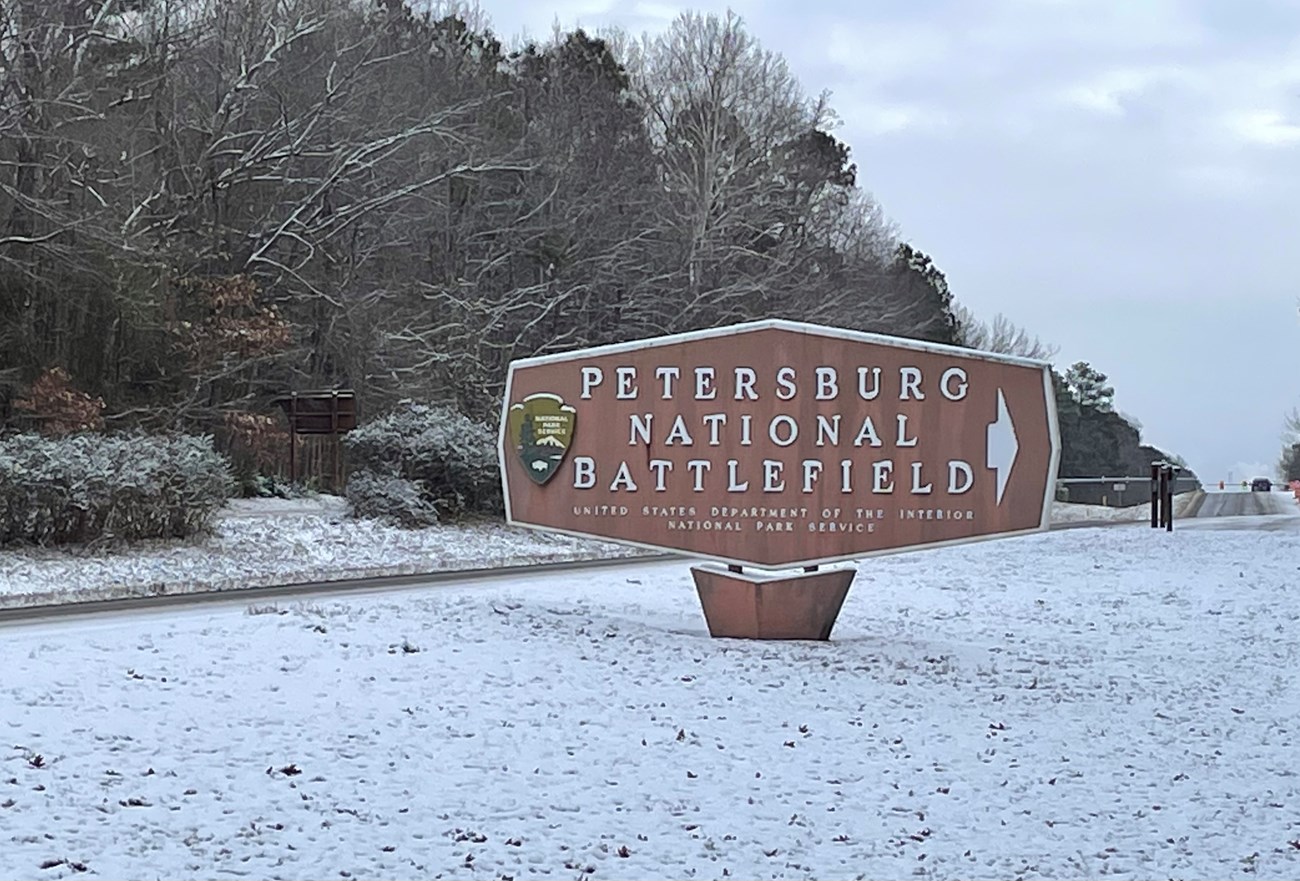 Sign reading Petersburg National Battlefield surrounded by snow.