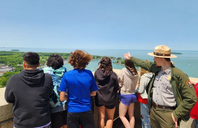 A ranger pointing to an island with a school group.