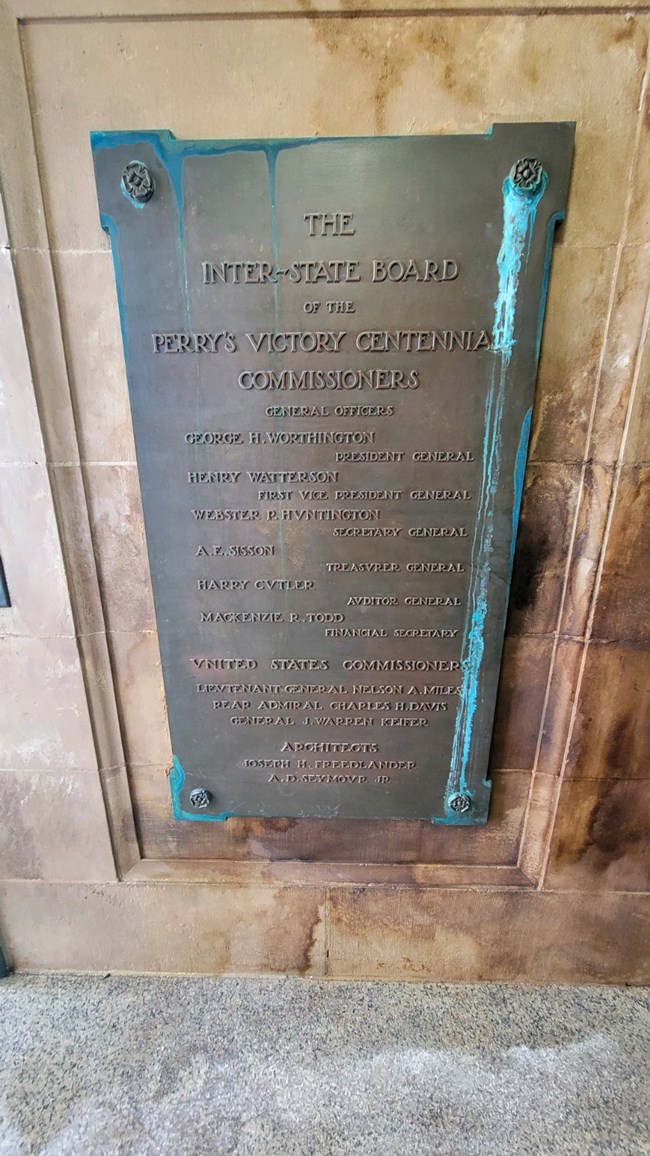 A bronze tablet with the names and titles of the Interstate Board of Perry's Victory Centennial Commissioners