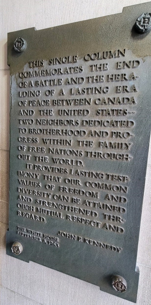 A bronze tablet hung on an entrance wall to a rotunda, with a 1963 commemoration from President John F Kennedy