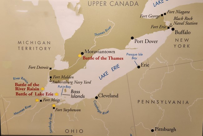 A tan and beige map of the US Terrritory and Canada surrounding Lake Erie in 1812. Significant towns are noted with a black circle or square. Five yellow fire images locate battles along the Great Lakes.