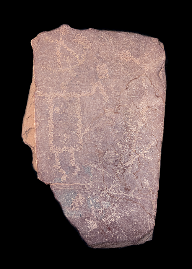 A reddish stone with engravings carved into it.