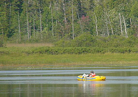 Boaters in a yellow inflatable raft enjoy an afternoon on Little Chapel Lake.