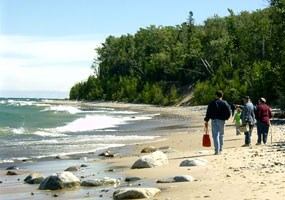 Visitors stroll along Twelvemile Beach as Lake Superior waves roll gently to shore.