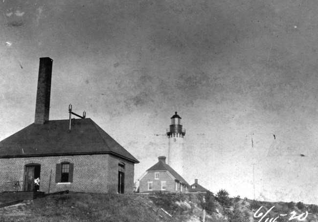 A historic photo of the Au Sable Light Station, as viewed from the water.
