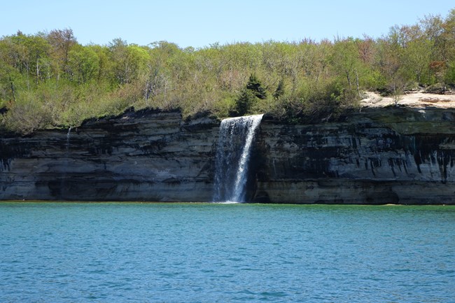 Waterfall flowing over the cliff into Lake Superior