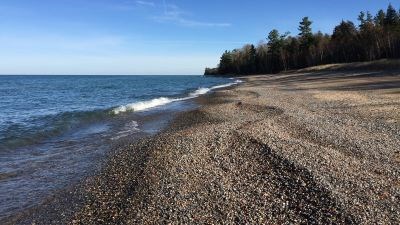Small stones make up much of the shoreline on the beach at Lake Superior Overlook.
