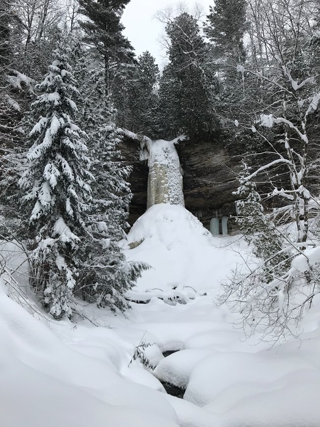 Frozen Munising Falls surrounded by snowing landscape