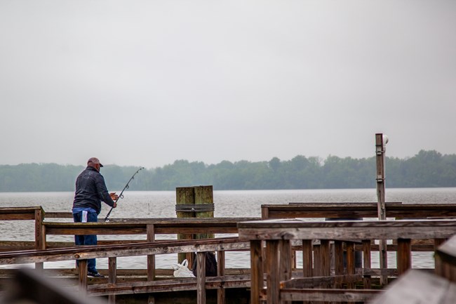 A fisherman on a wooden pier
