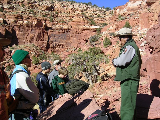 Ranger leads visitors on a guided hike in a redrock canyon.